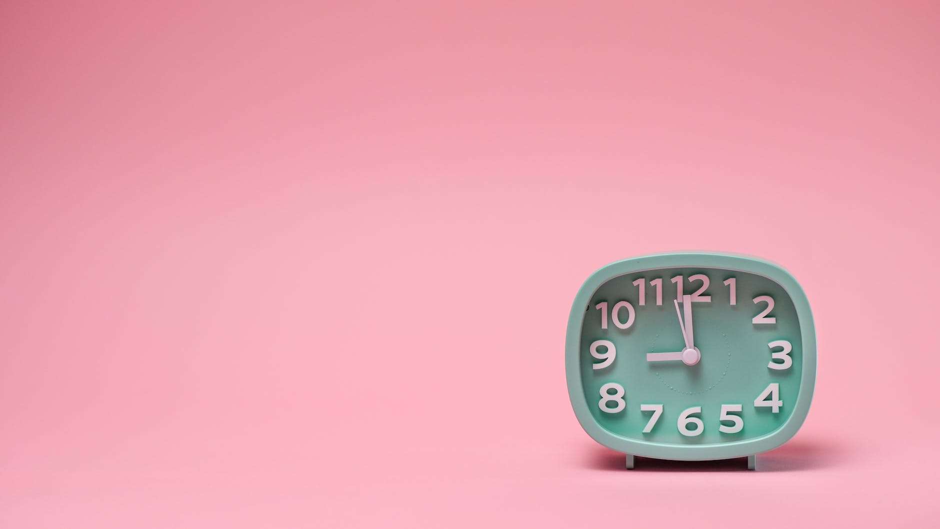 a clock on a pink background