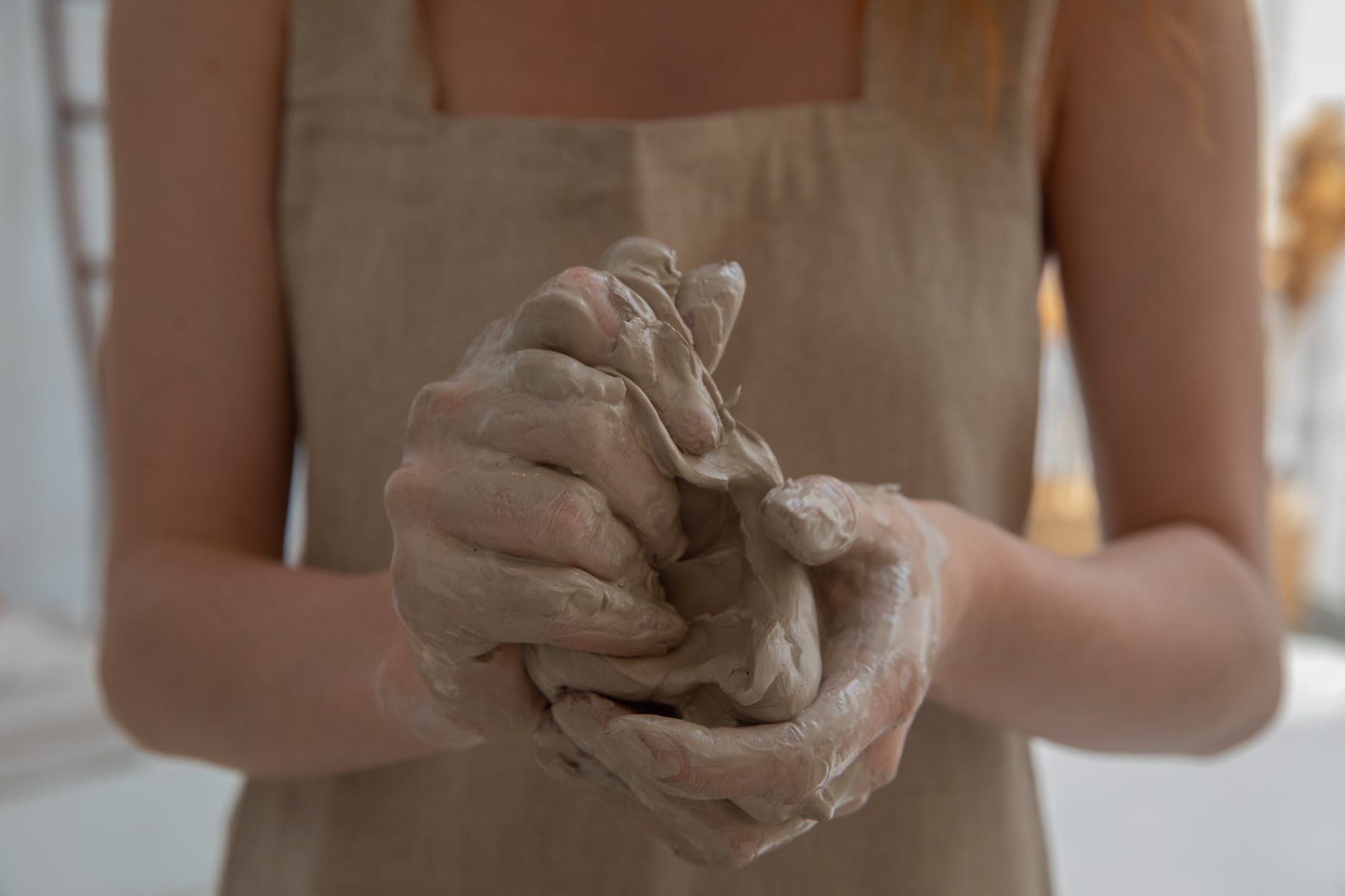 crop faceless woman kneading clay in workshop